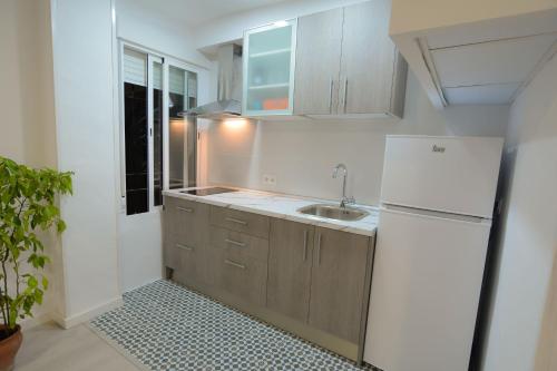 a kitchen with a white refrigerator and a sink at Apartamento En Los Patios De San Basilio in Córdoba