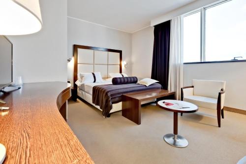 a hotel room with a bed and a chair at Italiana Hotels Cosenza in Cosenza