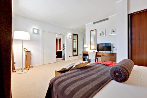 a bedroom with a bed and a living room at Italiana Hotels Cosenza in Cosenza