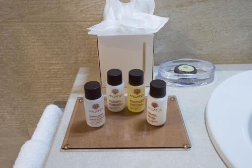 three bottles of moisturizers sitting on a table next to a tissue box at Borgo La Chiaracia Resort & SPA in Castel Giorgio