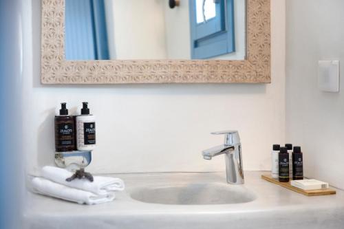 a bathroom with a sink with a mirror at Akrotiri Cove in Akrotiri