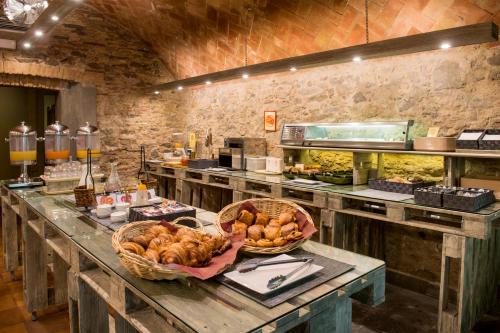 a kitchen with a table with baskets of food at Hotel Castell Blanc in Empuriabrava