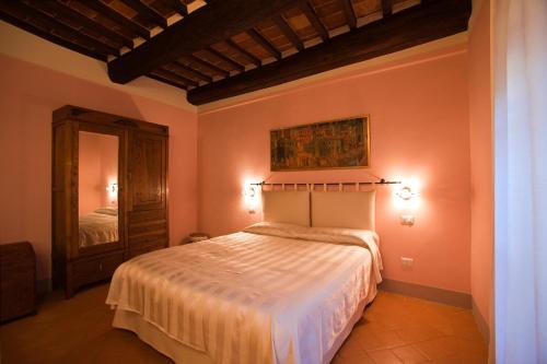 - une chambre avec un grand lit et un miroir dans l'établissement casa vacanze passignano, à Passignano sul Trasimeno