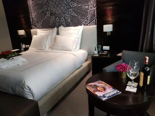 a hotel room with a bed and a table with a magazine at ODYSSEE Boutique Hotel Casablanca in Casablanca