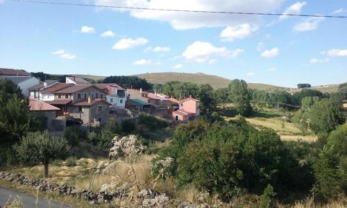 un grupo de casas al lado de una colina en Casa Rural Los Riscos de Gredos, en Hoyos de Miguel Muñoz