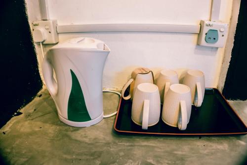 a small refrigerator with a coffee pot and four cups at Ipoh Boutique Stay in Ipoh