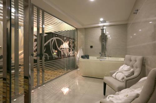 a bathroom with a tub and a chair and a sink at Al Muhaidb Residence Al Ahsa in Al Ahsa