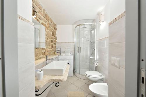 La salle de bains est pourvue d'un lavabo, de toilettes et d'une douche. dans l'établissement GRECALE a pochi passi dal mare, à Santa Maria Navarrese