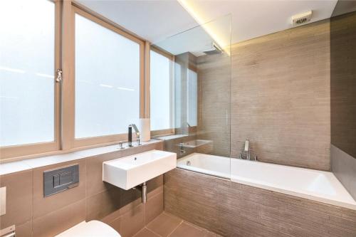 a bathroom with a sink and a bath tub at Luxury Apartments in Westminster in London