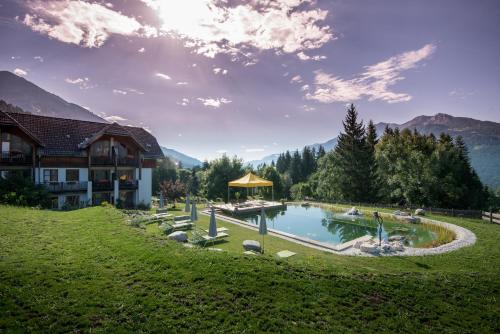 a house with a swimming pool in a grassy field at Naturhotel Landhof Irschen in Irschen