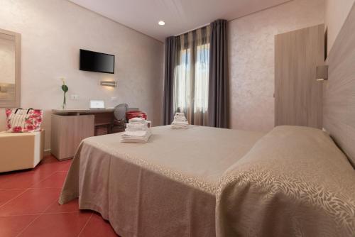 a hotel room with a large bed and a desk at Hotel Biancolilla in San Vito lo Capo