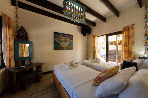 A bed or beds in a room at Villas des Alizes beachfront suites and garden villas