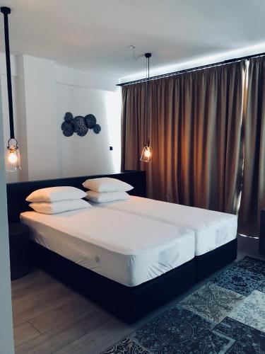 a bedroom with a large bed with white sheets and pillows at Abacus Suites in Ayia Napa