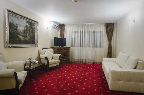 a living room with a couch and chairs and a tv at Hotel Capitol in Iaşi
