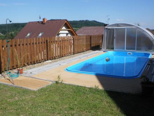 a swimming pool in a yard next to a fence at Apartman Daniela in Radvanice
