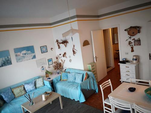 un soggiorno con divano blu e tavolo di Taormina Rising Sun Apt a Forza dʼAgro
