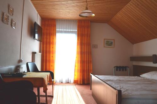 a bedroom with a bed and a desk and a window at Haus Brigitte in Fuschl am See