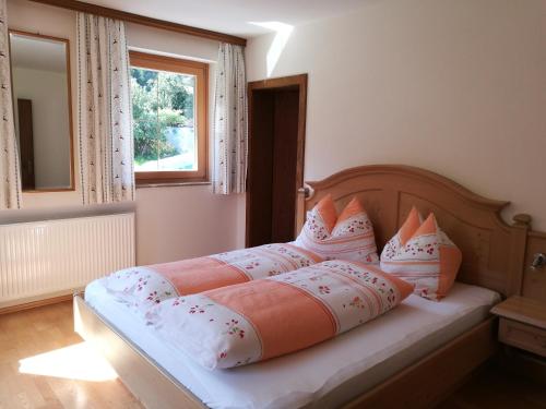 a bedroom with a bed with pillows and a window at Schartlhof in Flachau