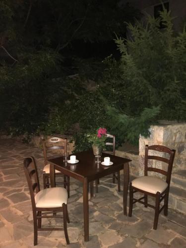 a wooden table and chairs with flowers on it at Xenonas Nikia in Yerákion
