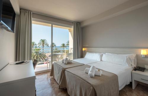 a hotel room with a bed and a large window at Rosamar Maritim 4* in Lloret de Mar