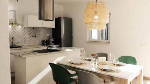 une cuisine avec une table blanche et des chaises ainsi qu'une salle à manger dans l'établissement Casa D' Avó Bia - Renovated House, à Aljezur