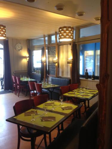 une salle à manger avec des tables et des chaises dans un restaurant dans l'établissement Hôtel La Tour D'Auvergne, à Pont-lʼAbbé