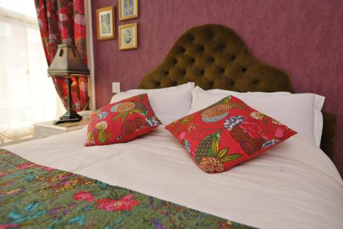 a bed with two red pillows on top of it at The Gallery in Blackpool