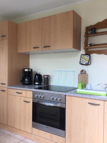 a kitchen with a black oven and wooden cabinets at Fewo Radebeul Altkötzschenbroda in Radebeul
