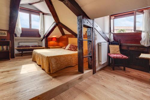 um quarto com uma cama num quarto com janelas em Ca' Badoer Attic em Veneza