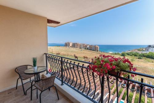 a balcony with a table and chairs and the ocean at Coral Luxury Villas in Lozenets