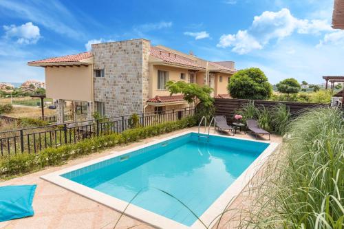 a swimming pool in front of a house at Coral Luxury Villas in Lozenets