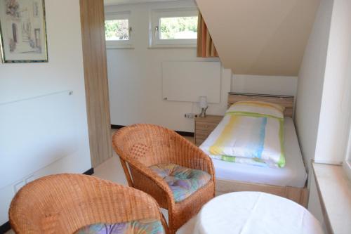 a small room with two chairs and a bed at Ferienwohnung Burgblick Bilstein in Bilstein