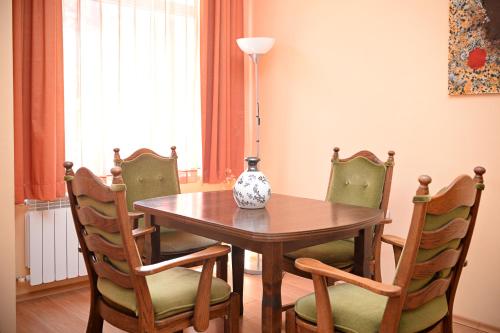 a dining room table with chairs and a vase on it at Family Art-Hotel Zora in Vratsa