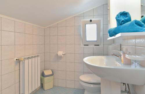 a bathroom with a sink and a toilet and a mirror at Apartments Aleksandra 1132 in Peroj