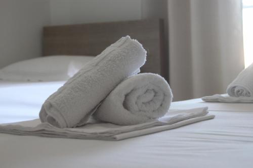 a roll of towels sitting on a bed at Vila Gjoni in Sarandë