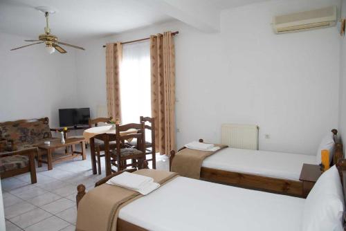 a bedroom with three beds and a dining room with a table at Hellenic Sun in Lassi