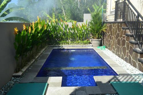 a small swimming pool in the middle of a garden at Villa Shanti Bali in Sempidi