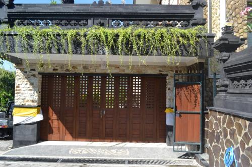a building with a brown door with plants on it at Villa Shanti Bali in Sempidi