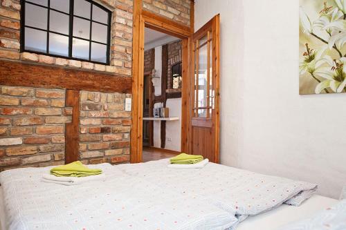 a bedroom with two beds in front of a brick wall at Ferienwohnungen und Ferienhäuser Gohr in Stralsund