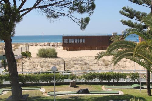 a park with the beach in the background at Hotel Vasco Da Gama in Monte Gordo
