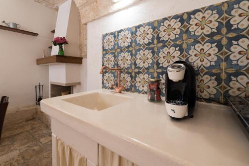 cocina con fregadero y pared de azulejos en Casa Villani Guest House Ostuni, en Ostuni