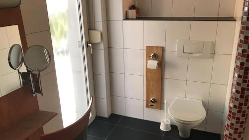 a small bathroom with a toilet and a mirror at Hotel-Nachtwächter in Unna