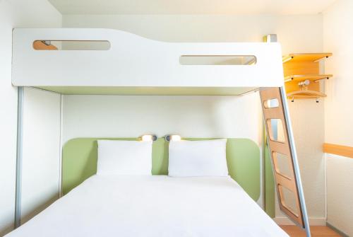 a bedroom with a bunk bed with white bedding at ibis budget Paris Porte de Bercy in Charenton-le-Pont