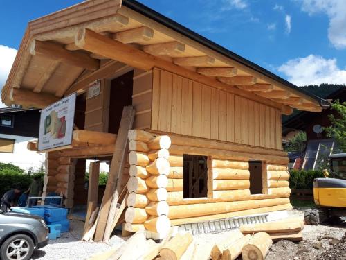a log cabin being built with a pile of logs at Chalet Karin in Hochfilzen
