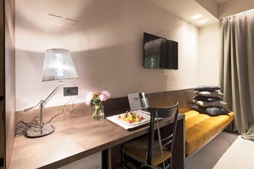 a room with a desk with a lamp and a couch at Albavilla Hotel & Co in Albavilla