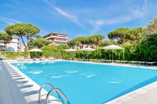 a large swimming pool with chairs and umbrellas at Italiana Hotels Florence in Florence