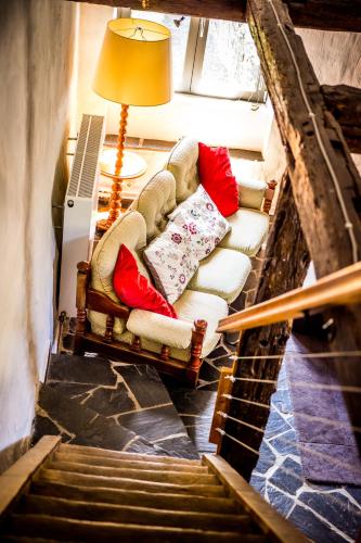 a living room with a chair and a lamp and stairs at La Retirée in Grimbiémont