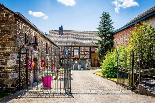 an entrance to an old brick house with a wrought iron gate at La Retirée in Grimbiémont