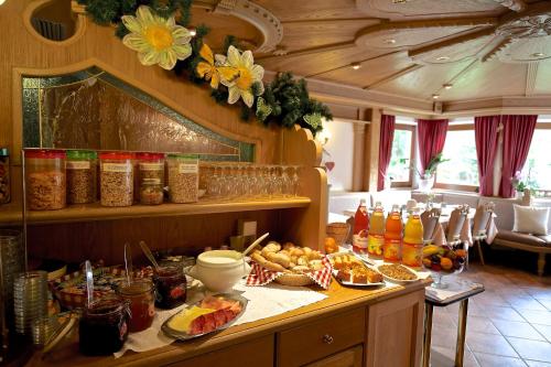 eine Küche mit einem Buffet mit Speisen und Getränken in der Unterkunft Hotel Val in Wolkenstein in Gröden