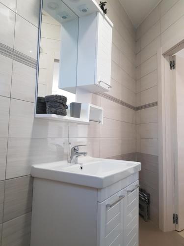 a white bathroom with a sink and a mirror at eVita Fazana Premium Studio Apartments in Fažana